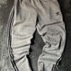 Pantalon Adidas gris lineas negras no original