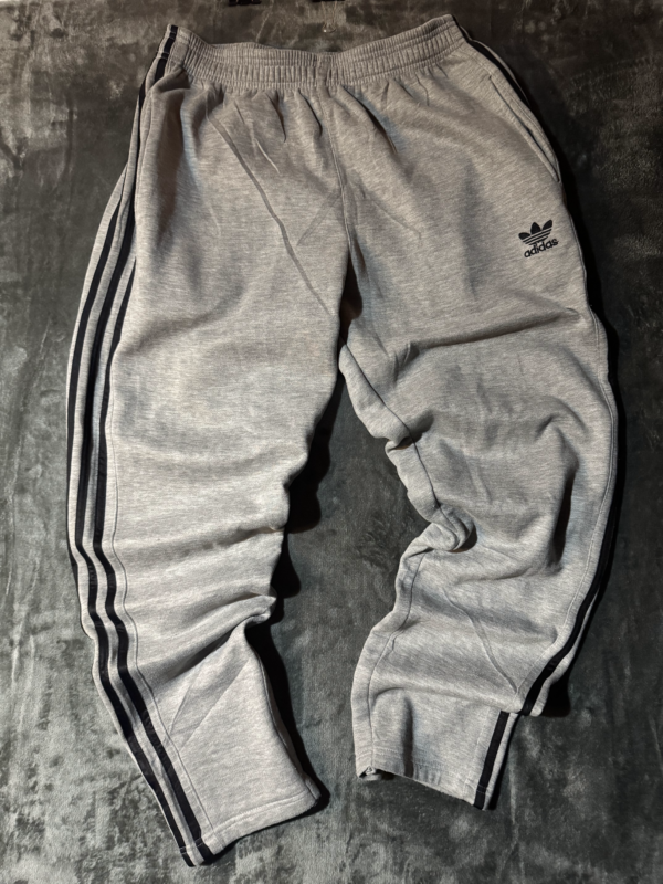Pantalon Adidas gris lineas negras no original