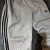 Pantalon Adidas gris lineas negras no original