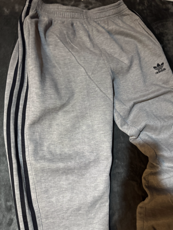 Pantalon Adidas gris lineas negras no original