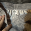 Pantalon Adidas gris lineas negras no original